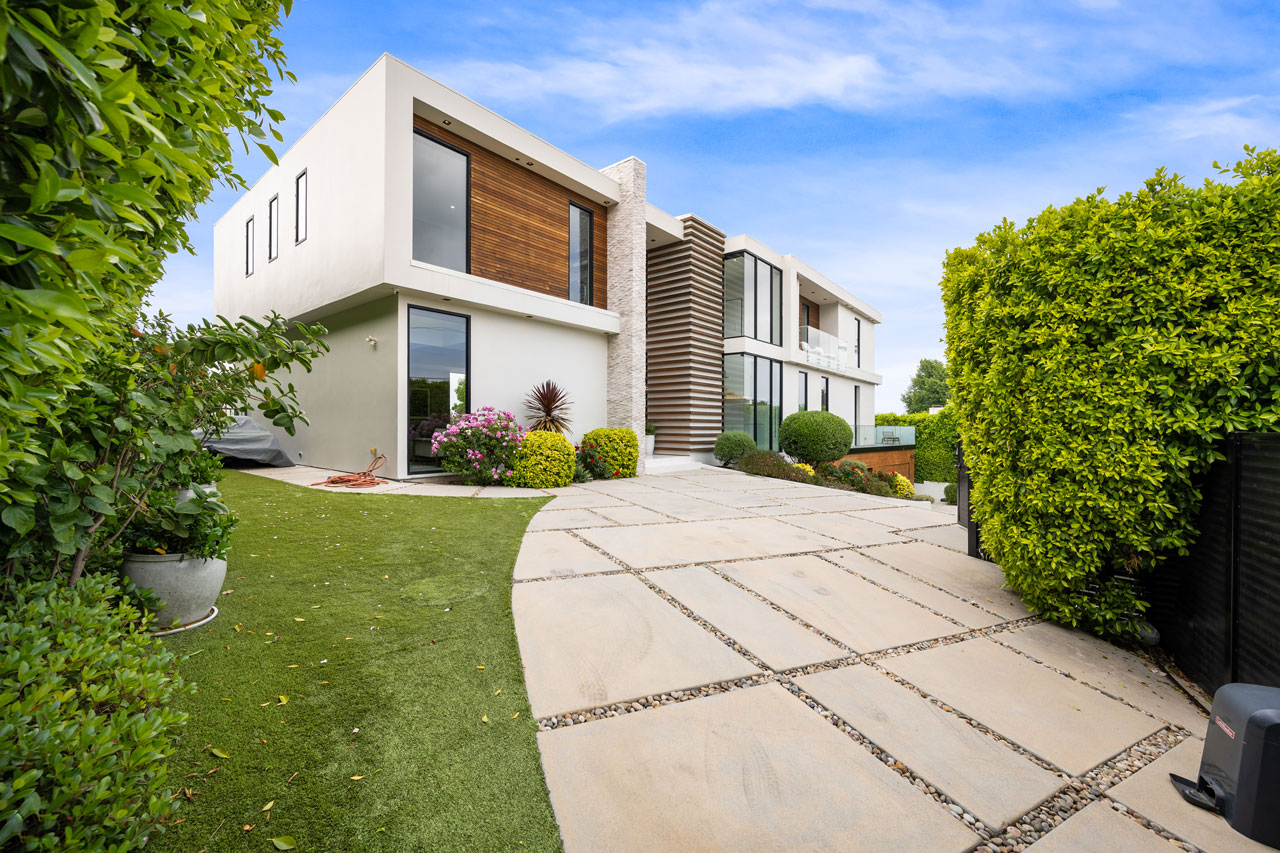 Modern rental property managed by a property management company, featuring a landscaped yard and sleek architectural design.