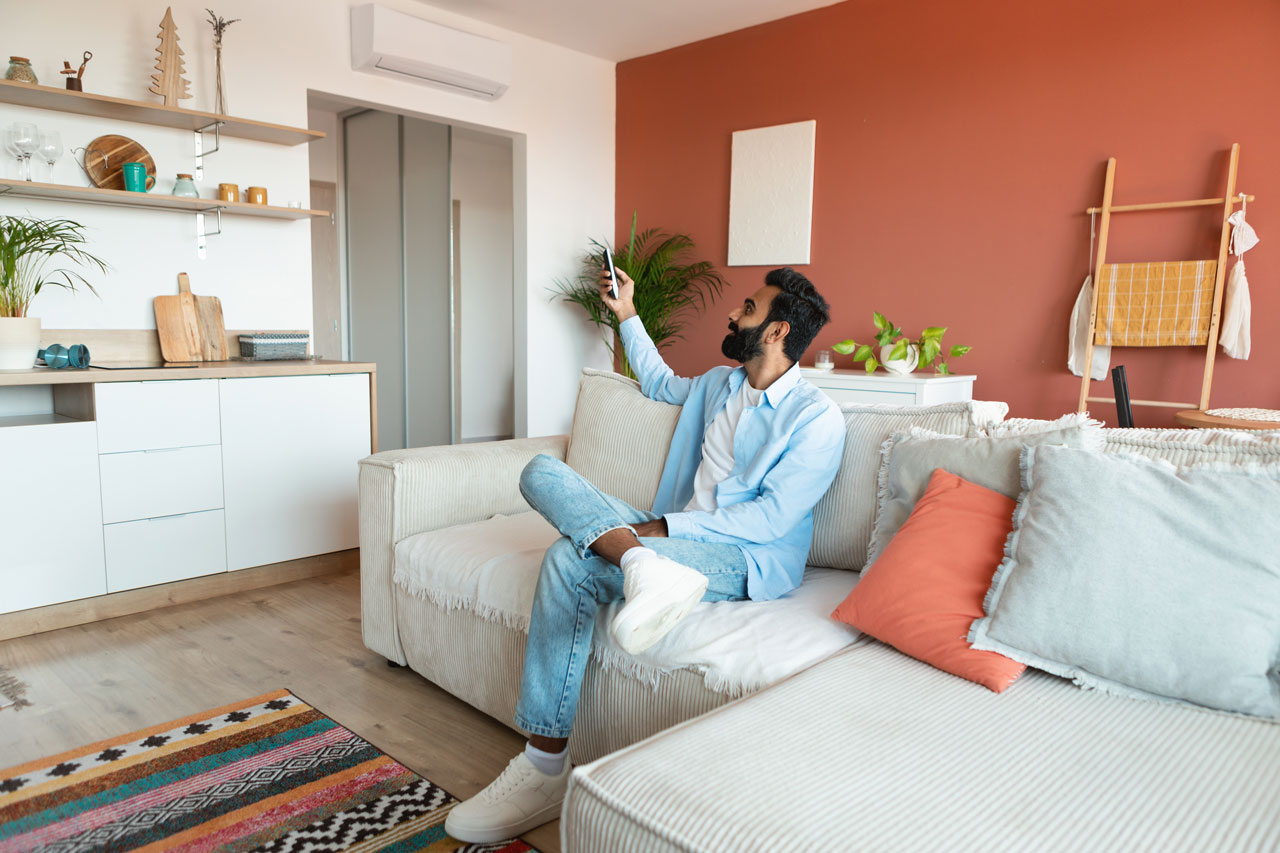 Young man relaxing in a well-decorated rental apartment, demonstrating how to make rental property more attractive